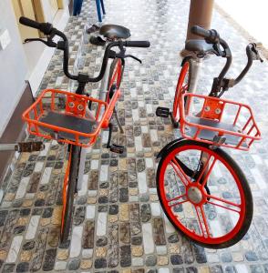 un vélo orange avec roues rouges garé sur un trottoir dans l'établissement Desa Besut Inn, à Kampung Kuala Besut