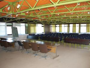 una sala de conferencias con mesas y sillas en un edificio en Holiday Park CFK, en Vrbas