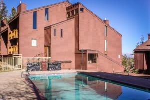 a house with a swimming pool in front of a building at Mammoth Ski & Racquet 30 in Mammoth Lakes