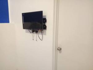 un televisor colgado en una pared junto a una puerta en Zoom BnB en Naga