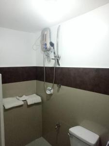a bathroom with a shower and a toilet with towels at Zoom BnB in Naga