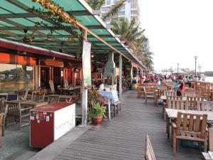 a wooden boardwalk with tables and chairs and a restaurant at 5 Bedrooms Penthouse 3 Bedrooms Apartment Marina Court Resort Condominium in Kota Kinabalu