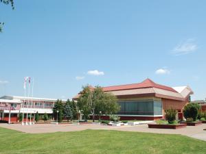 a school building with a green lawn in front of it at Holiday Park CFK in Vrbas