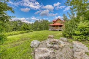 ein Blockhaus mit einer Feuerstelle im Hof in der Unterkunft Log Cabin Escape in Jacksonville