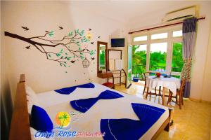 a bedroom with a bed with a tree mural on the wall at Owin Rose Yala Safari Hotel in Tissamaharama