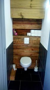 a small bathroom with a toilet with a wooden wall at Loft mezzanine verrière avec vue in Saint-Denis