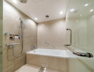 a bathroom with a shower and a bath tub at Daiwa Roynet Hotel Kyoto Terrace Hachijo PREMIER in Kyoto