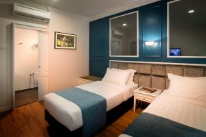 Pokój hotelowy z 2 łóżkami i lustrem w obiekcie H Boutique Hotel Sri Petaling w Kuala Lumpur