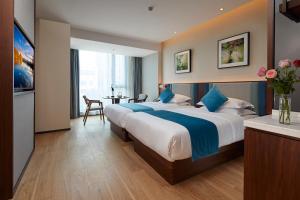 揚州市にあるSSAW Boutique Hotel Yangzhouの大きなベッドとテーブルのあるホテルの部屋