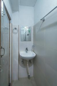 a white bathroom with a sink and a shower at Shristi Hotel & Lodge in Bandīpur