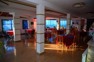 波格拉德茨的住宿－Joni Restaurant，一间带桌椅和红色桌布的用餐室