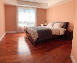 a bedroom with a bed and a wooden floor at Nice rooms with private bath in Mid Town Toronto in Toronto