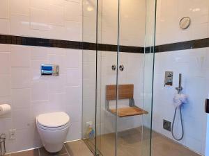 uma casa de banho com um WC e uma cabina de duche em vidro. em Nice rooms with private bath in Mid Town Toronto em Toronto