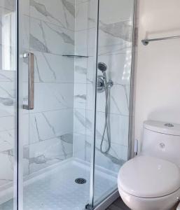 a white bathroom with a shower and a toilet at Nice rooms with private bath in Mid Town Toronto in Toronto