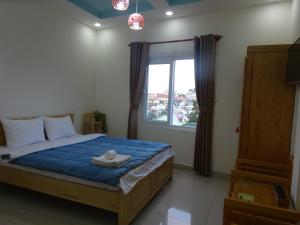 a bedroom with a bed and a large window at Cam Ly Homestay in Da Lat