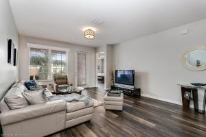 ein Wohnzimmer mit einem Sofa und einem Flachbild-TV in der Unterkunft Miranda's Gem Condo in Orlando