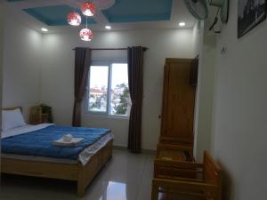 een slaapkamer met een bed en een raam bij Cam Ly Homestay in Da Lat