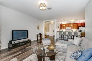 ein Wohnzimmer mit einem weißen Sofa und einem TV in der Unterkunft Miranda's Gem Condo in Orlando