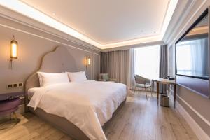 a hotel room with a large bed and a television at Mercure Ordos Downtown in Ordos +55 photos