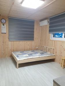 a bedroom with a bed in a wooden room at Grace River House Block A - Couple Room in Hoengsong