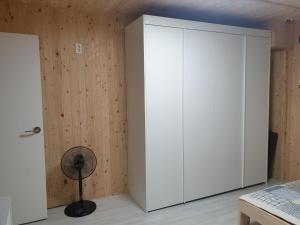 a bedroom with a white cabinet and a fan at Grace River House Block A - Couple Room in Hoengsong