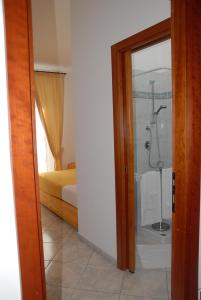 a room with a bathroom with a shower and a bedroom at Il Cinghialetto in Fonni