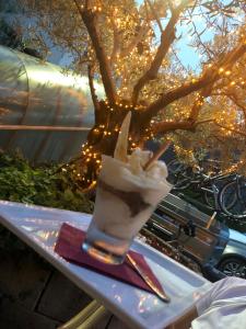 un bicchiere di gelato su un tavolo accanto a un albero di Hotel Concordia a Porlezza