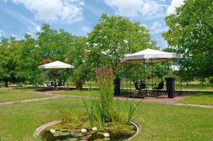 a park with two umbrellas and a table and chairs at Eichenhof Hotel GbR in Eislingen
