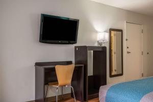 a bedroom with a bed and a tv on the wall at Motel 6-Rocky Mount, NC in Rocky Mount