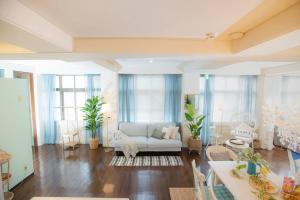 a living room with a white couch and some windows at White House in Uruma