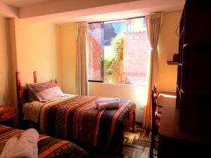 Habitación pequeña con cama y ventana en Full Suites, en Cusco