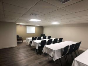 a conference room with tables and chairs and a screen at Best Western Jamaica Inn in Queens