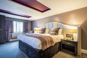 a bedroom with a large bed and a large window at Clarion Hotel Newcastle South in Sunderland