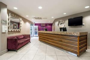 a lobby with a bar with a tv and a couch at Clarion Hotel Newcastle South in Sunderland