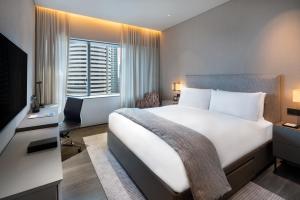 una habitación de hotel con una cama y un televisor en Dao by Dorsett AMTD Singapore, en Singapur