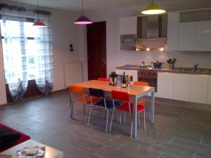 een keuken met een tafel en stoelen in een kamer bij Casetta San Giovanni in Barolo