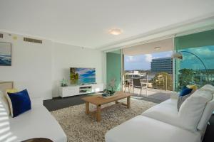 a living room with two white couches and a large window at m1 Resort in Maroochydore