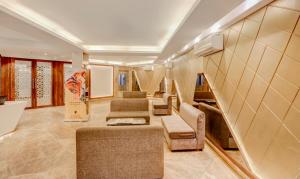 sala de estar con escaleras, sofá y sillas en Treebo Trend Radhe Palace en Calcuta