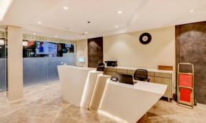 a lobby with a desk with a laptop on it at Treebo Trend Radhe Palace in Kolkata