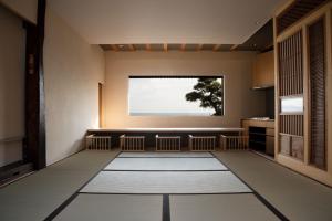 um quarto com uma grande janela e um tapete branco em modern ryokan kishi-ke em Kamakura