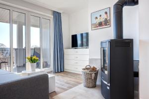 a living room with a fireplace and a tv at Aparthotel Villa Lea in Ahlbeck
