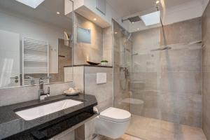 ein Bad mit einem WC, einem Waschbecken und einer Dusche in der Unterkunft Aparthotel Villa Lea in Ahlbeck
