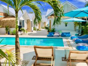 a resort pool with chairs and a palm tree at So KohKoon Beach Resort in Bang Rak Beach