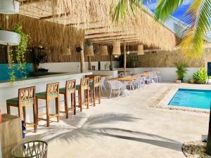 a bar with tables and chairs next to a swimming pool at So KohKoon Beach Resort in Bang Rak Beach