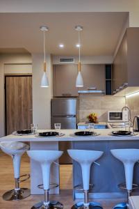 a kitchen with white counter tops and bar stools at Keramikos Comfortable apartment #1 in Athens