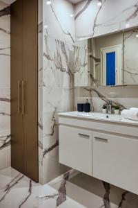 a white bathroom with a sink and a mirror at Keramikos Comfortable apartment #1 in Athens