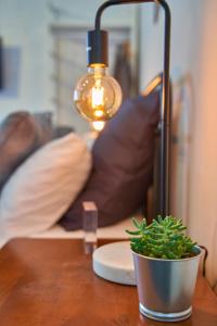 una mesa con una lámpara y una maceta en ella en The Blender Loft en Melbourne