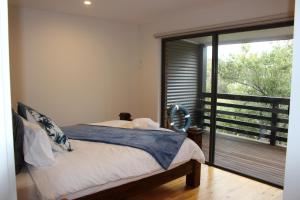 a bedroom with a bed and a large window at kanburra house in Rye