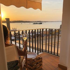 a woman sitting in a chair with a glass of wine at Can Nicasi in L'Escala