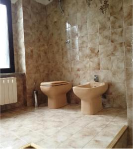 a bathroom with a toilet and a sink at La villa più bella con piscina in Treglio